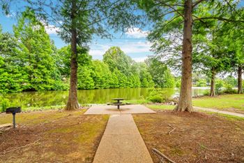a picnic table in a park next to a river at The Oliver Apartment Homes, Olive Branch, MS, 38654